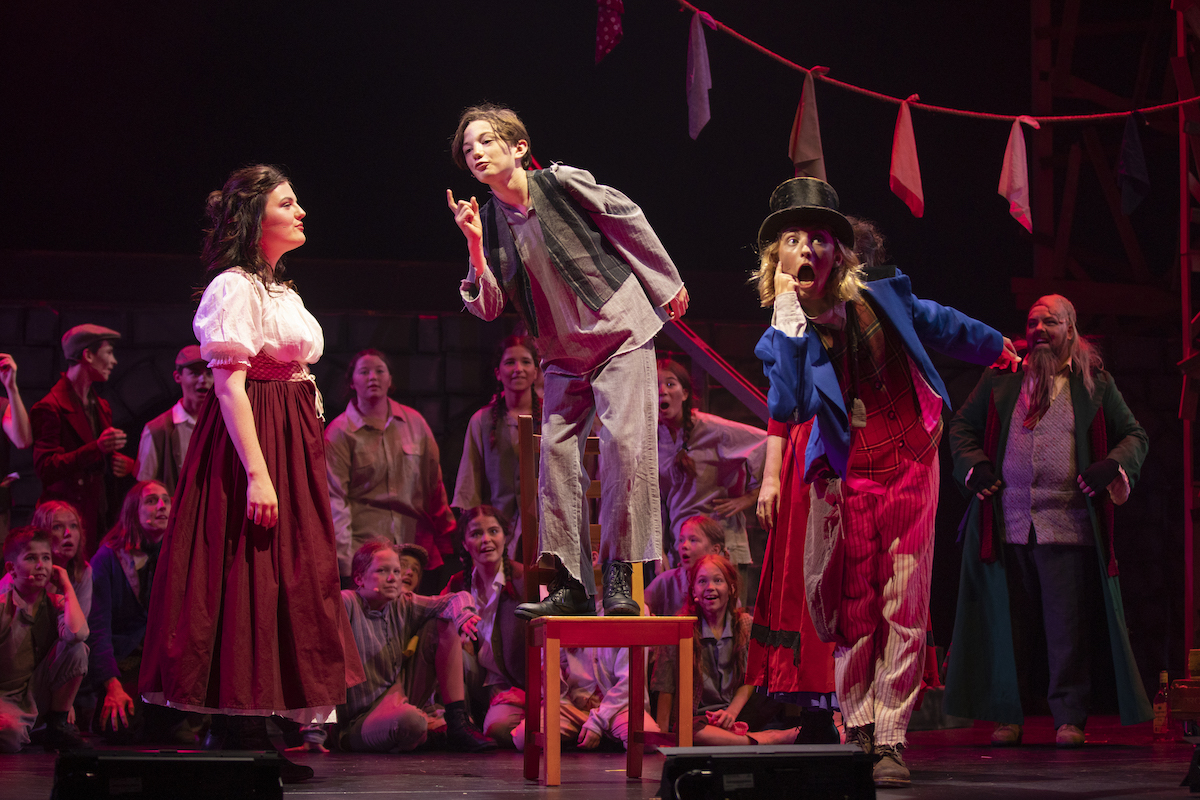 students performing Oliver on stage